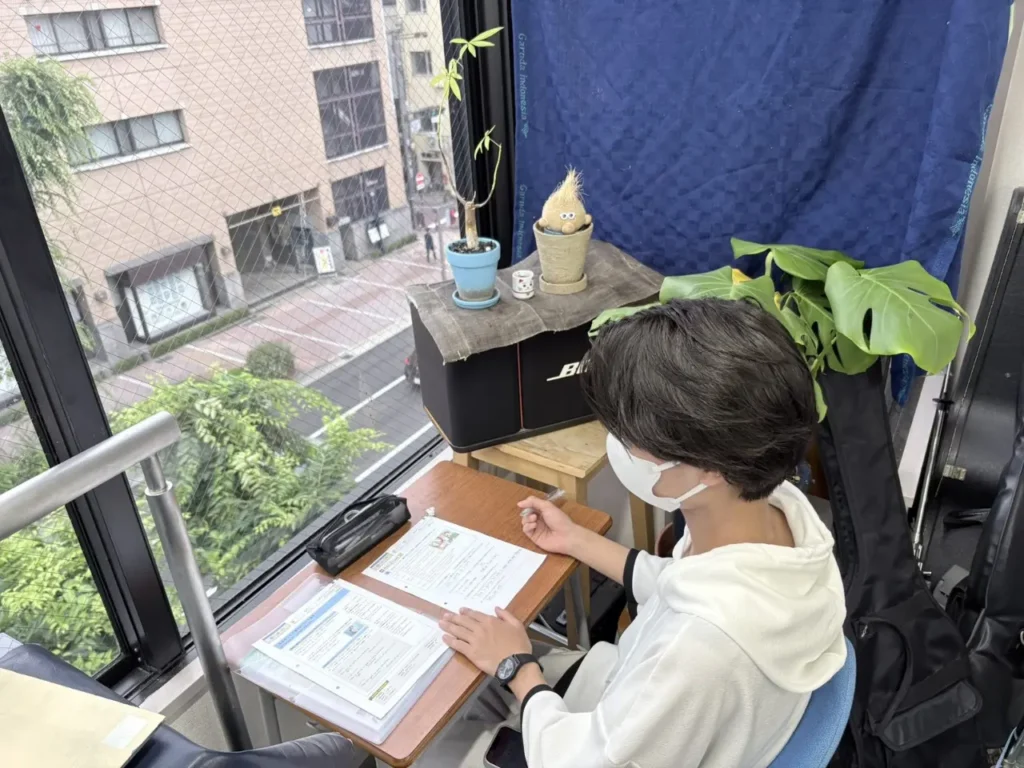窓際の席で自分のペースで学習する中学生